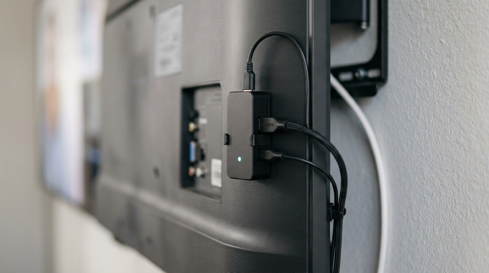 AirSign-enheten ansluten till baksidan av en väggmonterad TV-skärm via HDMI och nätverkskabel